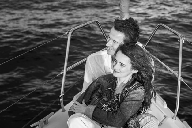 Black and white image of a couple laying in the front part of a boat during an engagement photoshoot in the Azores