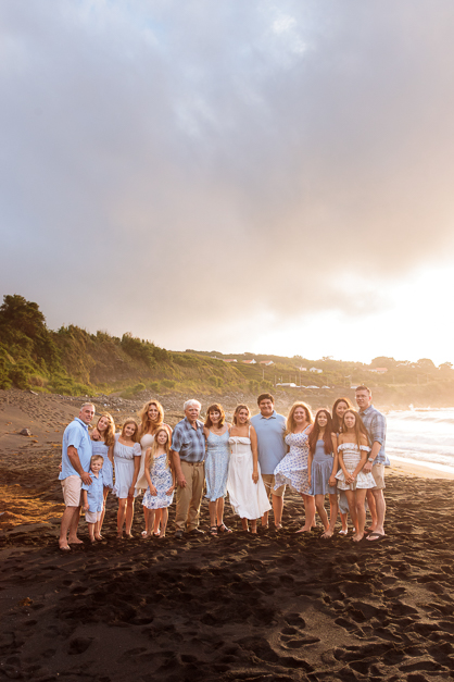 Big family posing during a family session in the Azores at a vulcanic beach during sunset