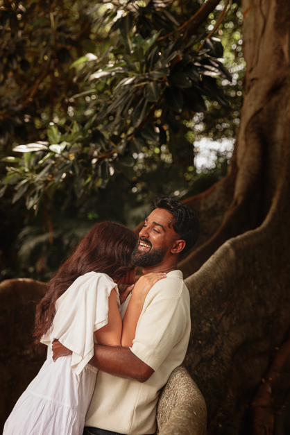 Couple laughes and lays over a tree during a couple session in the Azores