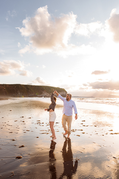 Guy makes his girlfriend spin in an empty beach right after his surprise proposal at an engagement session in the Azores