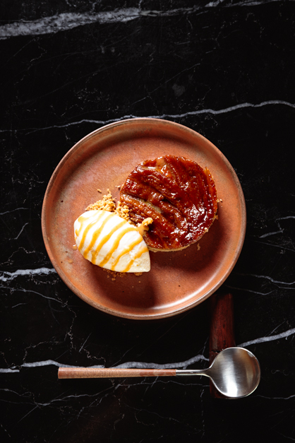 A dessert dish lays on top of a dark table on a restaurant in the Azores