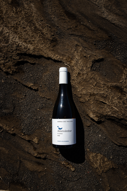 Bottle of azorean wine lays over some natural patterns in the Azores