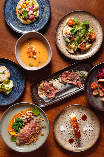 Layover image of a table full of dishes for a restaurant session in the Azores